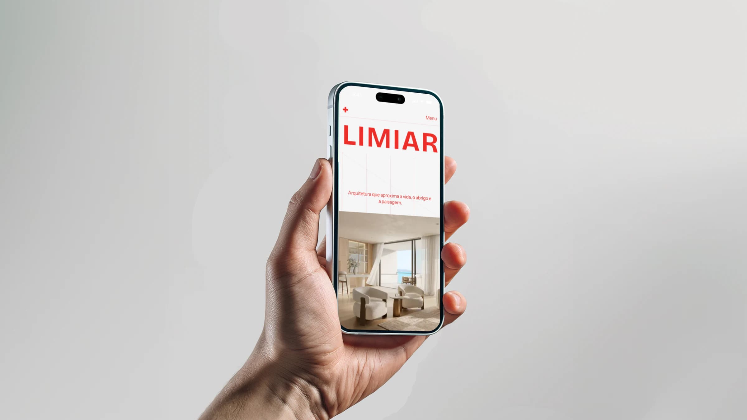 Uma mão segura um celular com a página inicial do Limiar.