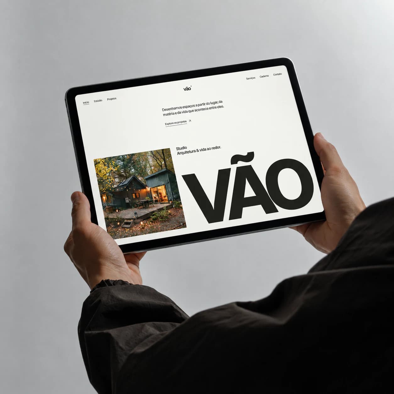 Uma pessoa segura um tablet com a página inicial do VÃO Studio na tela.